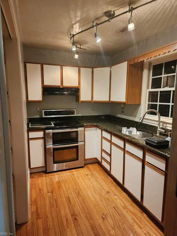 kitchen featuring sink, white cabinetry, double oven range, range hood, and light wood-type flooring