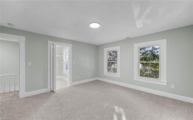 carpeted empty room with baseboards