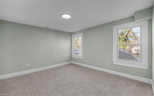 carpeted empty room featuring visible vents and baseboards