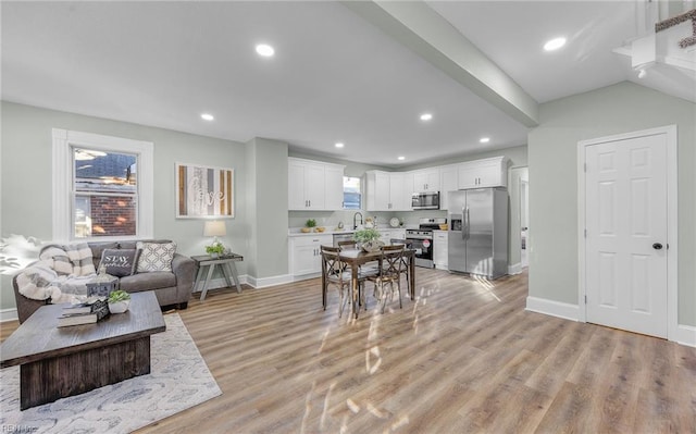 living room featuring sink and light hardwood / wood-style floors