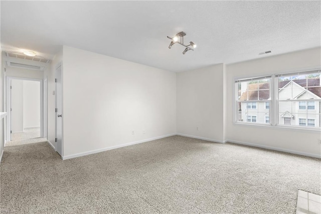 spare room with carpet flooring and a textured ceiling