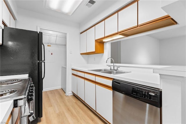 kitchen with white cabinetry, stainless steel appliances, sink, and light hardwood / wood-style flooring