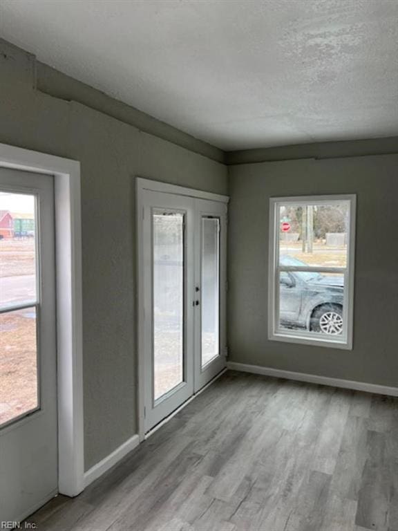 unfurnished room with a textured ceiling and light hardwood / wood-style floors