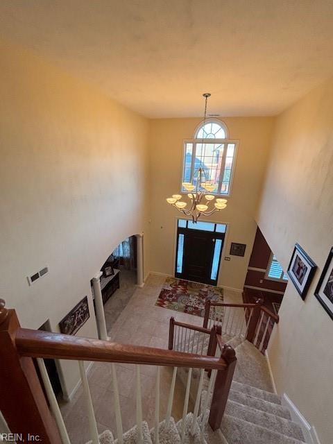 foyer featuring a towering ceiling and a chandelier