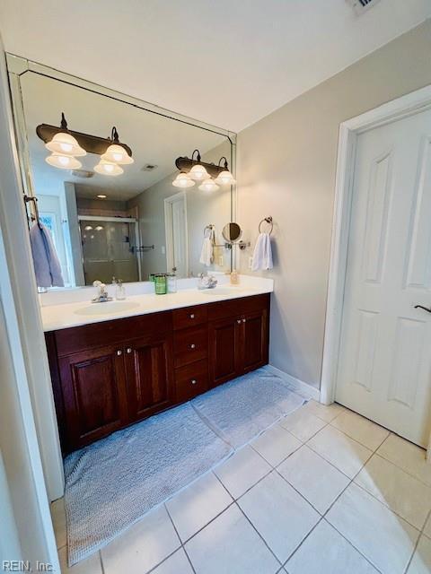 bathroom featuring vanity, an enclosed shower, and tile patterned floors