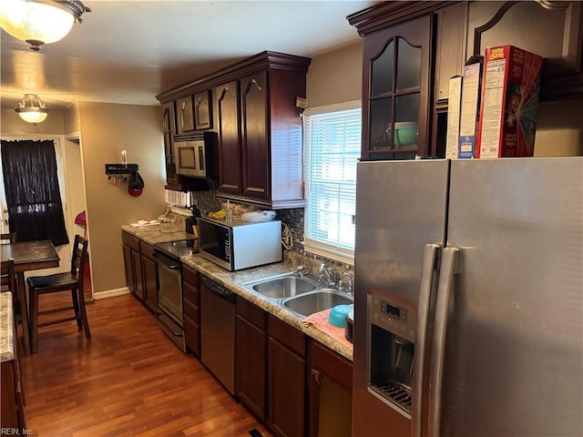 kitchen featuring stainless steel appliances, sink, backsplash, and dark brown cabinetry