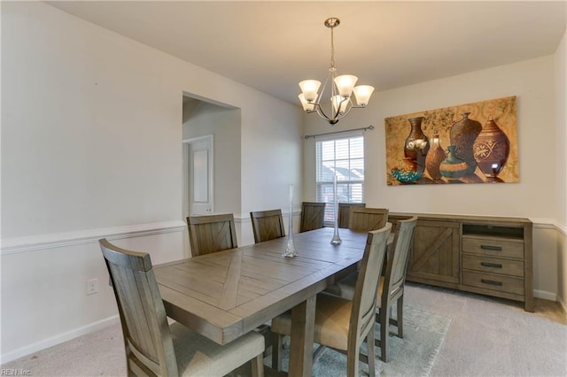 carpeted dining area with a chandelier