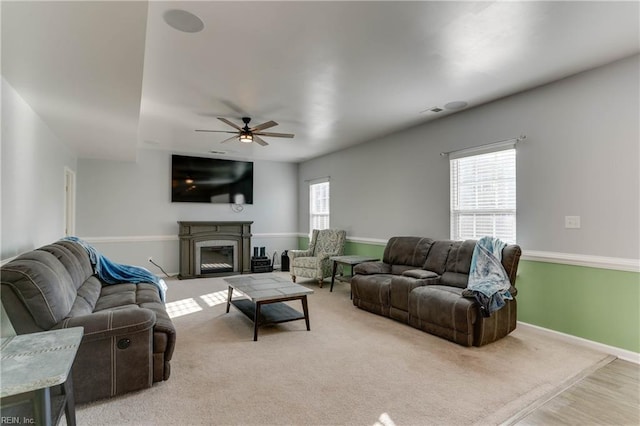 carpeted living room with ceiling fan