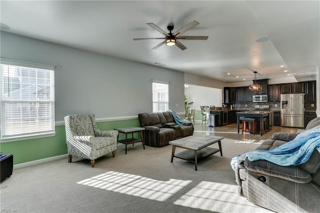 living room with light colored carpet and ceiling fan