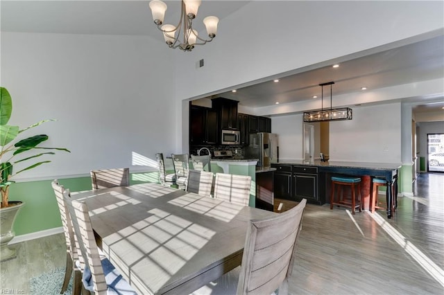 dining space featuring an inviting chandelier and light hardwood / wood-style flooring