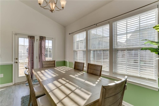 unfurnished dining area with lofted ceiling, hardwood / wood-style floors, and a chandelier