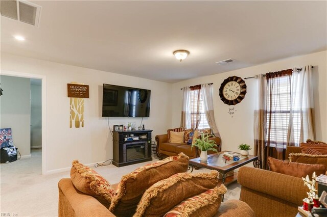 living room with light colored carpet and a fireplace