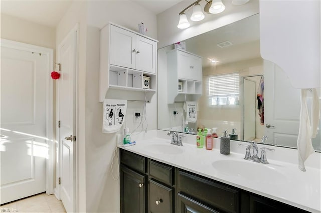 bathroom featuring a shower with door, vanity, and tile patterned floors