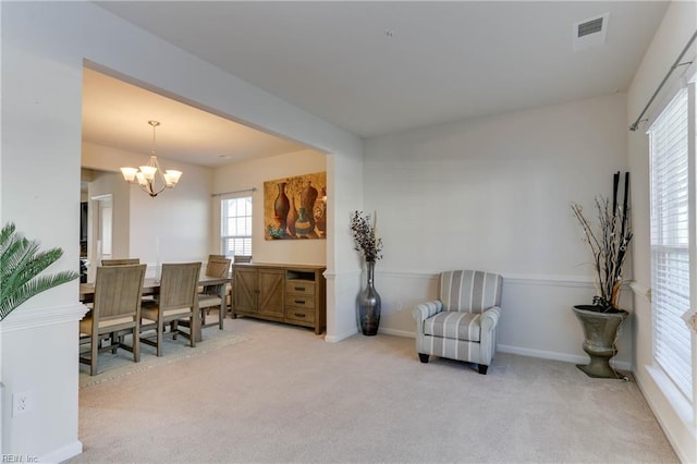 carpeted home office featuring an inviting chandelier