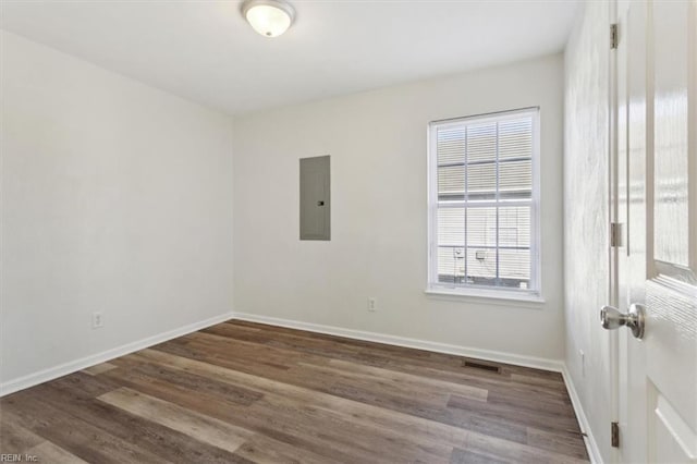 unfurnished room featuring electric panel and dark hardwood / wood-style flooring