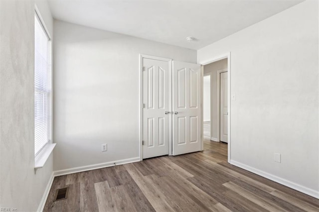 unfurnished bedroom with hardwood / wood-style flooring and a closet