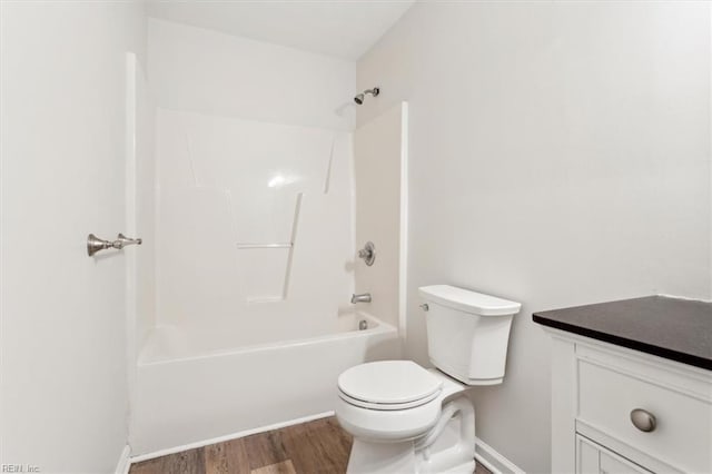 bathroom with bathing tub / shower combination, hardwood / wood-style floors, and toilet