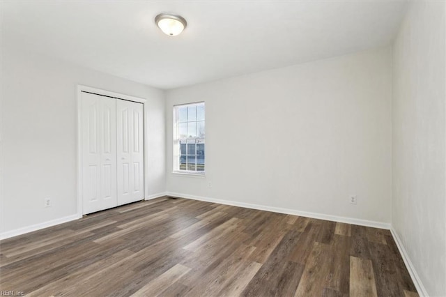 unfurnished bedroom featuring dark hardwood / wood-style floors and a closet