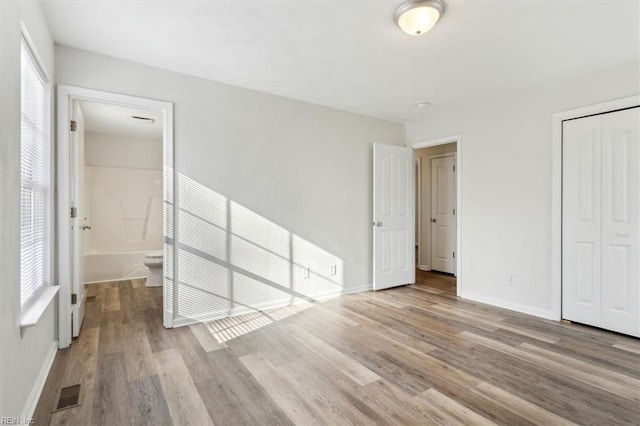 unfurnished bedroom with a closet and light wood-type flooring