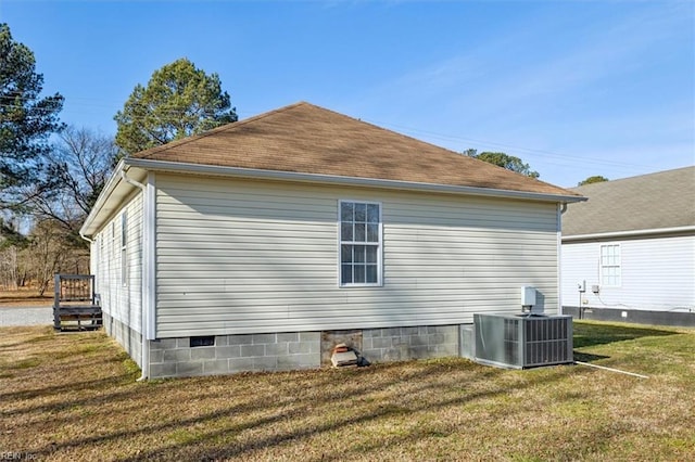 view of side of home with central AC unit and a lawn