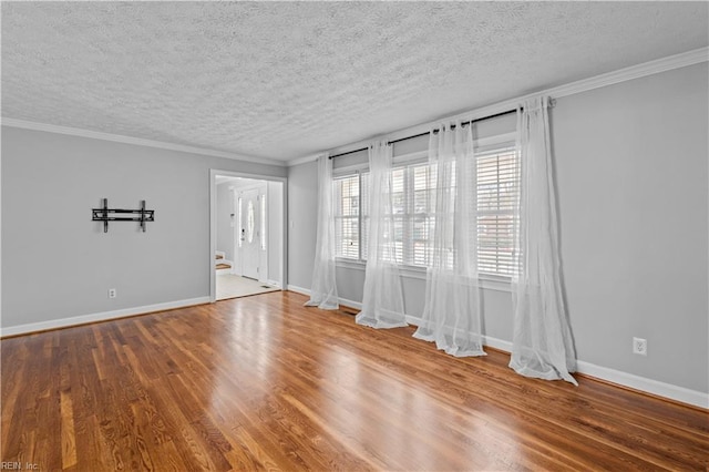 empty room with hardwood / wood-style flooring, ornamental molding, and a textured ceiling