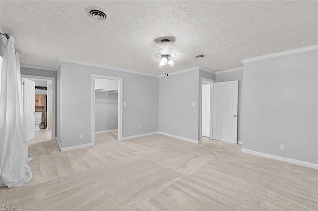 unfurnished bedroom featuring ornamental molding, light colored carpet, and a textured ceiling