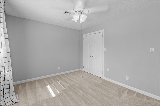 unfurnished room with light carpet, a textured ceiling, and ceiling fan