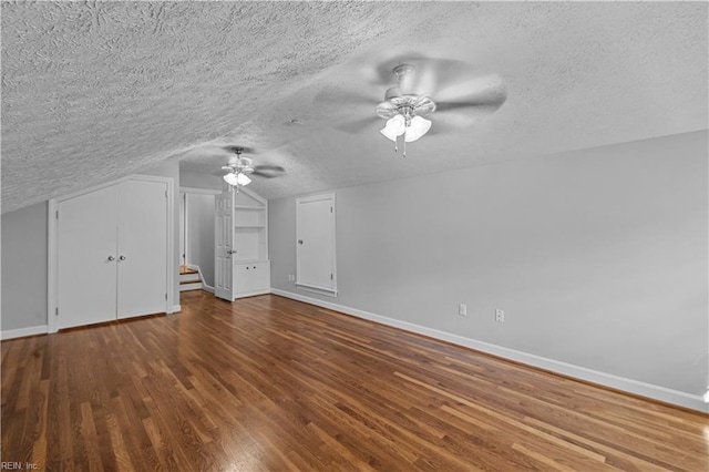 bonus room featuring ceiling fan, wood-type flooring, vaulted ceiling, and a textured ceiling