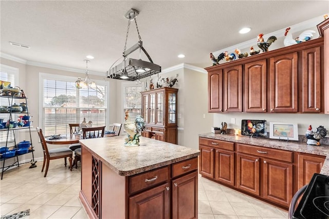 kitchen with crown molding, light tile patterned floors, decorative light fixtures, and a kitchen island