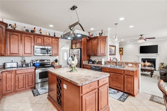 kitchen featuring pendant lighting, sink, appliances with stainless steel finishes, ornamental molding, and a kitchen island