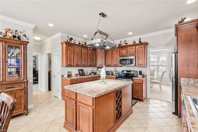 kitchen with appliances with stainless steel finishes, decorative light fixtures, ornamental molding, a center island, and light tile patterned floors