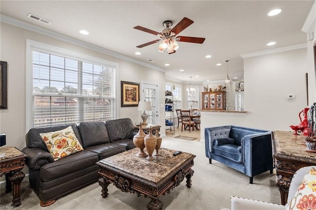 carpeted living room featuring ornamental molding and ceiling fan