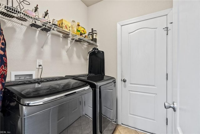 laundry room with washing machine and dryer and light tile patterned floors