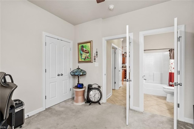 carpeted bedroom with ensuite bath and a closet