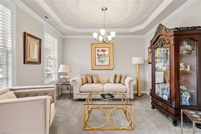 carpeted living room featuring crown molding, a raised ceiling, and a chandelier