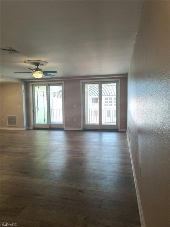 spare room with dark wood-type flooring and ceiling fan