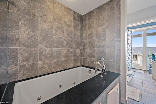 bathroom with a relaxing tiled tub, tile patterned flooring, and tile walls