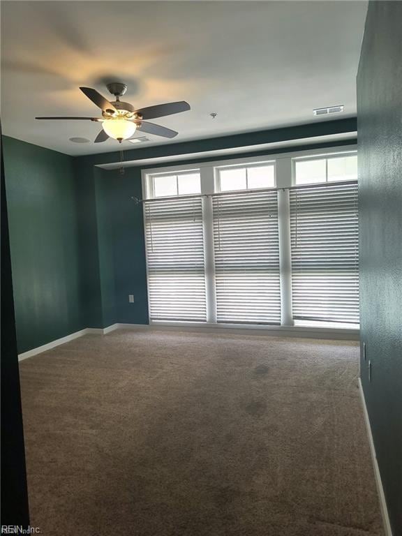 carpeted spare room with ceiling fan