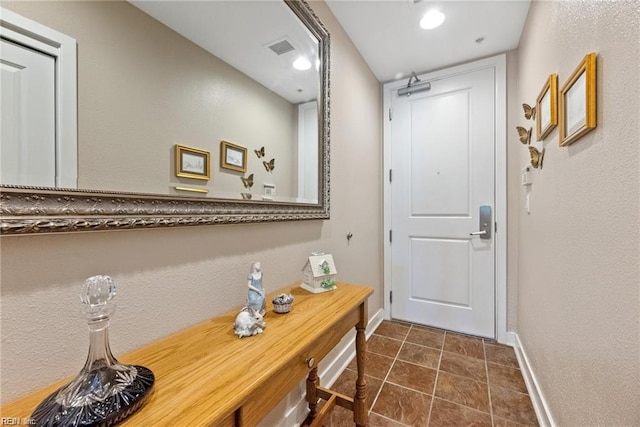 entryway with dark tile patterned floors