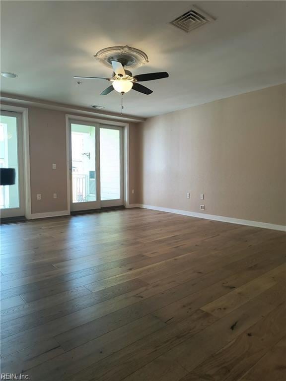 unfurnished room featuring dark hardwood / wood-style floors and ceiling fan