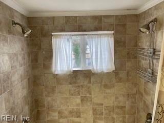 bathroom featuring ornamental molding and tiled shower