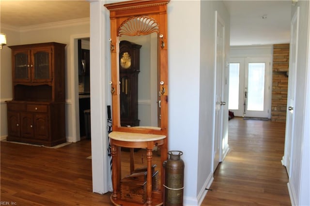 corridor with ornamental molding, dark hardwood / wood-style floors, and french doors