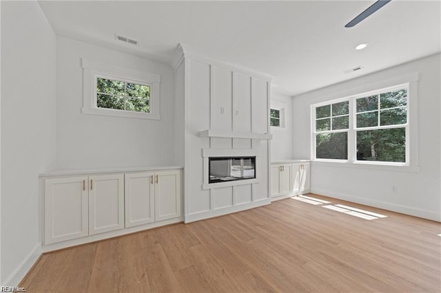 unfurnished living room featuring a fireplace and light hardwood / wood-style flooring