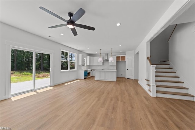 unfurnished living room with ceiling fan and light hardwood / wood-style flooring