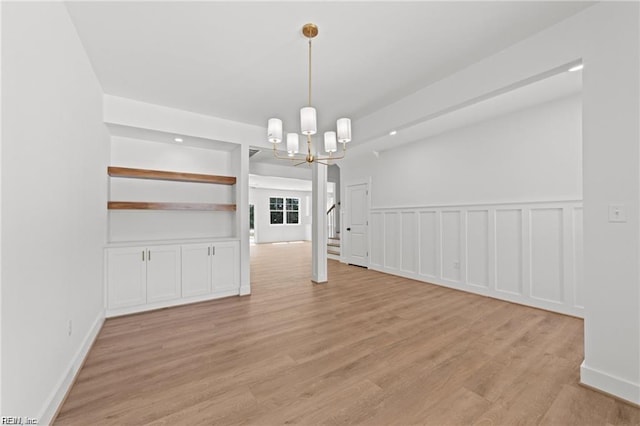 unfurnished dining area with a chandelier and light hardwood / wood-style floors