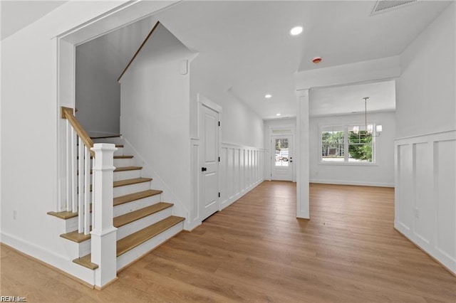 stairway featuring a notable chandelier and hardwood / wood-style flooring