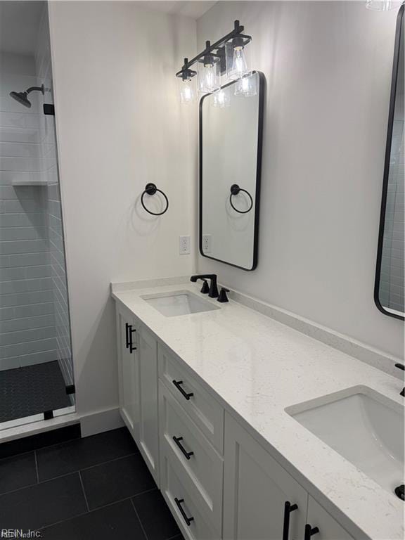 bathroom with tile patterned flooring, vanity, and tiled shower