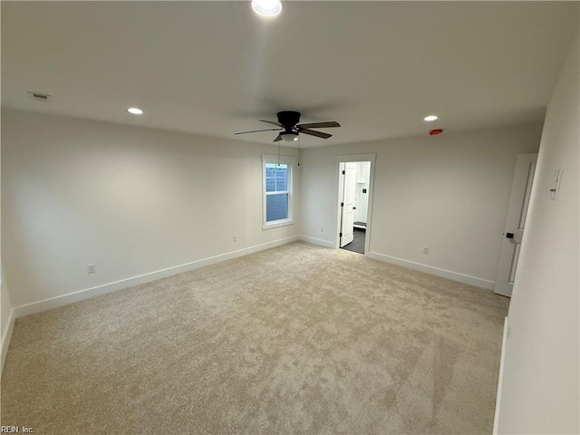 spare room with light colored carpet and ceiling fan