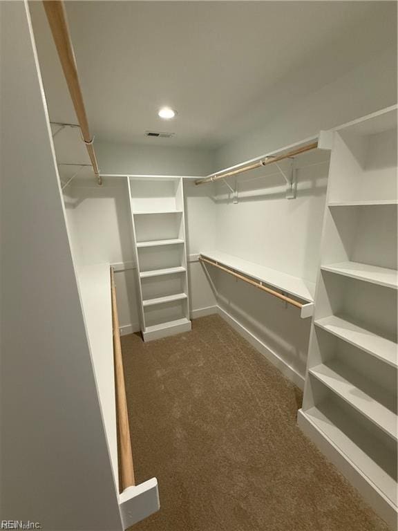 spacious closet featuring dark colored carpet