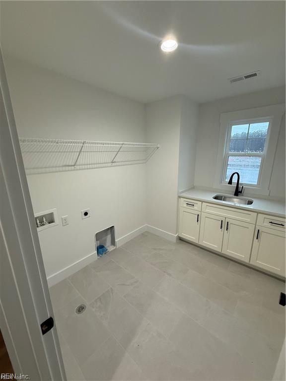 laundry room with hookup for a washing machine, sink, hookup for an electric dryer, and cabinets